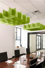 Lime green three-dimensional cloud-shaped acoustic baffles suspended from ceiling above conference table.