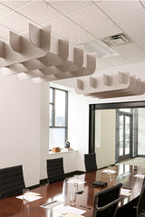 Beige 3D cloud-shaped acoustic baffles suspended from ceiling above conference table in office space.