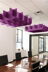 Purple 3D cloud-shaped acoustic baffles suspended from ceiling above conference table.