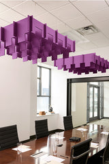 Purple 3D modular baffle system suspended from ceiling in office conference room above wooden table.