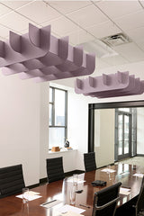 Purple cloud-shaped acoustic baffles suspended from ceiling above conference table in office space.