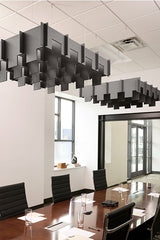 Gray 3D modular cloud baffles suspended from ceiling above conference table in office space.