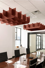 Terracotta-red 3D cloud-shaped acoustic baffles suspended from a drop ceiling above a conference table.