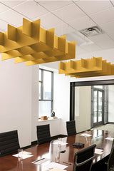Yellow 3D grid acoustic baffles suspended from drop ceiling in office meeting room with conference table.