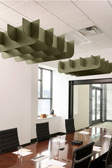 Sage green 3D cloud-shaped acoustic baffles suspended from office ceiling above conference table.