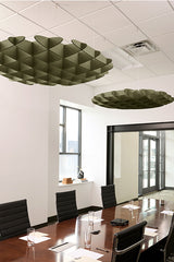 Olive-green 3D cloud-shaped acoustic baffles suspended from ceiling in modern office space.