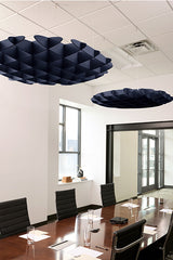 Two dark blue 3D cloud-shaped acoustic baffles suspended from a drop ceiling in an office conference room.