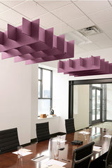 Purple geometric acoustic baffles suspended from ceiling in modern office conference room above wooden table.