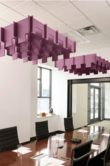Purple 3D modular acoustic baffle panels suspended from ceiling above conference table in office space.
