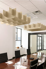 Beige 3D cloud-shaped acoustic baffles suspended from ceiling above conference table in modern office.