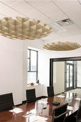 Beige 3D cloud-shaped acoustic baffles suspended from ceiling above conference table.