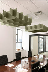 Green cloud-shaped acoustic baffles suspended from ceiling above conference table in office space.