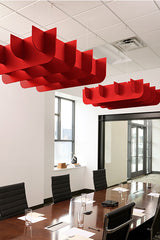 Red 3D cloud-shaped acoustic baffles suspended from ceiling in modern office conference room.
