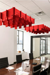 Red 3D modular cloud baffles suspended from ceiling in office conference room.