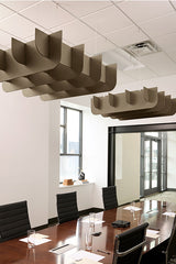 Two tan 3D cloud-shaped acoustic baffles suspended from ceiling in modern office conference room.