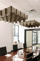Tan 3D cloud-shaped acoustic baffle suspended from ceiling above conference table in office space.