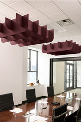 Burgundy cloud-shaped acoustic baffles suspended from ceiling in modern office conference room.
