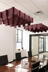 Burgundy 3D cloud-shaped acoustic baffles suspended from ceiling above conference table.