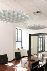White 3D cloud-shaped acoustic baffles suspended from ceiling in modern office meeting room.