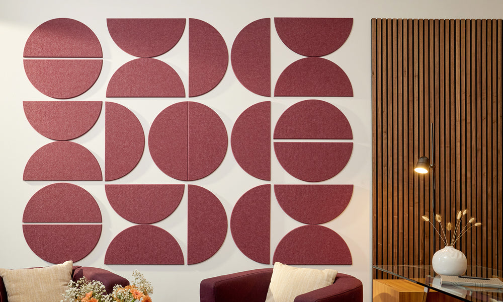 Maroon half circles of felt acoustic wall panels in an office with two chairs