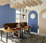 A modern office interior with several wooden desks, mesh office chairs, blue and beige arched wall panels, and decorative ceiling elements. No people or animals are present, but this is still a real environment rather than a clean isolated product shot, so subject_type is Lifestyle.