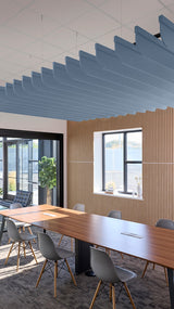 Blue curved acoustic baffles suspended from ceiling in modern office conference room with wood wall paneling.