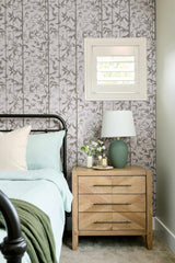 Bedroom with floral wallpaper, wooden nightstand, and decorative items.