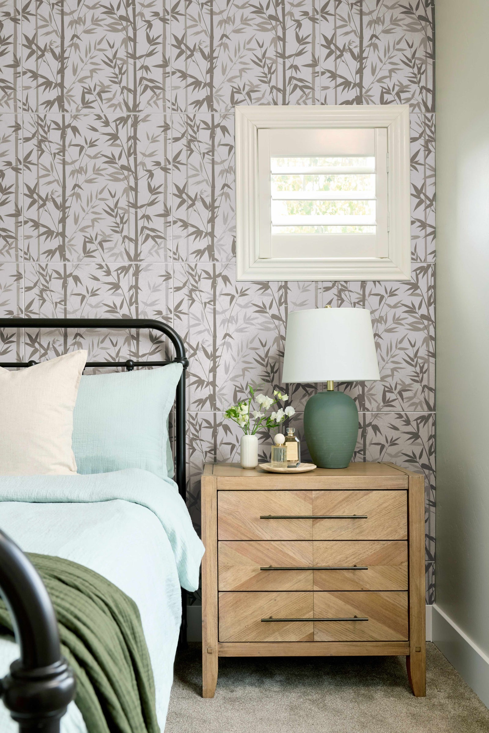 Bedroom with floral wallpaper, wooden nightstand, and decorative items.