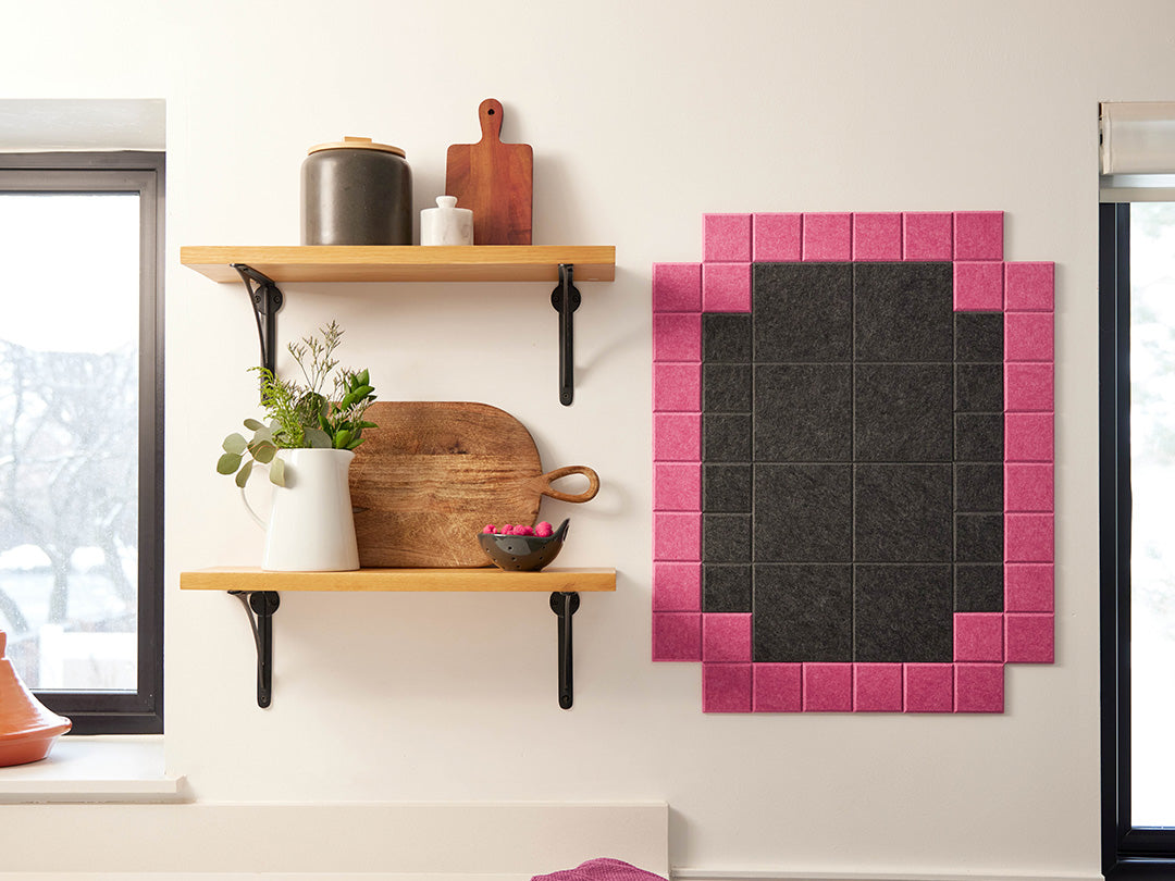 Kitchen wall with wooden shelves and a pink and black tiled mirror.