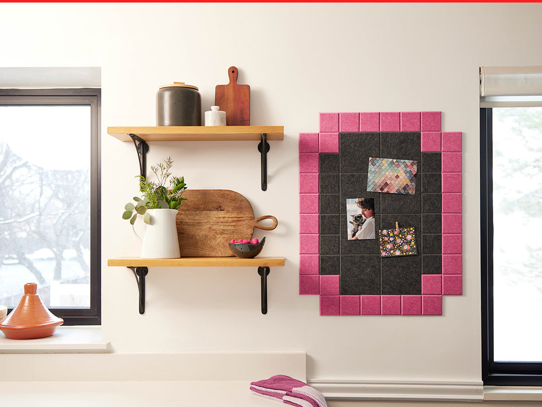 Decorative wall shelf with pink and black tiled panel in a kitchen setting