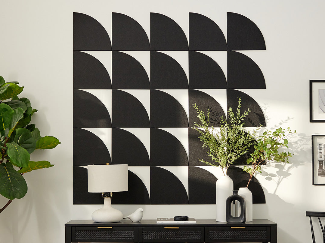 Black and white geometric wall art with a console table and decorative items.
