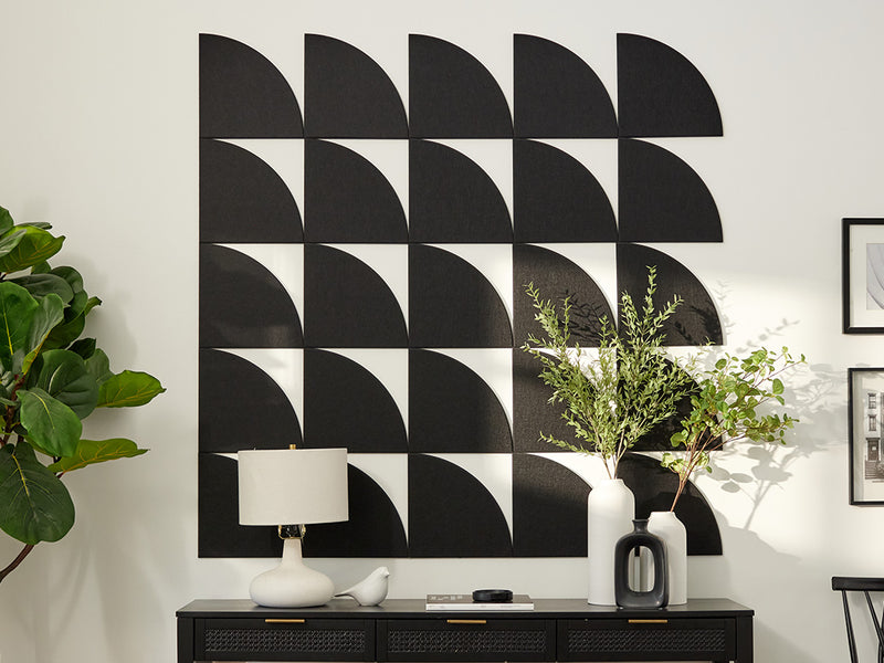 Black and white geometric wall art with a console table and decorative items.