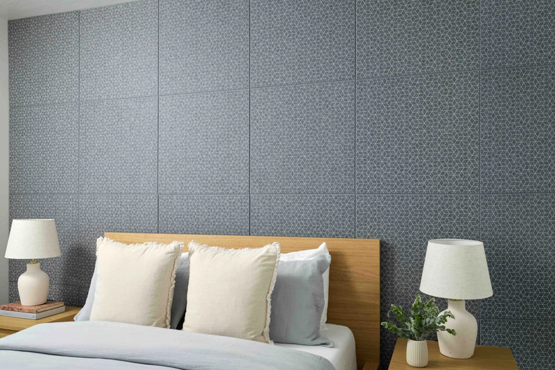 Modern bedroom with a bed, nightstands, and lamps against a textured gray wall.