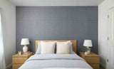 Bedroom with wooden headboard and nightstands against a textured gray wall.