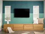 Modern living room with wooden TV stand, television, and decorative items against a blue and green patterned wall.