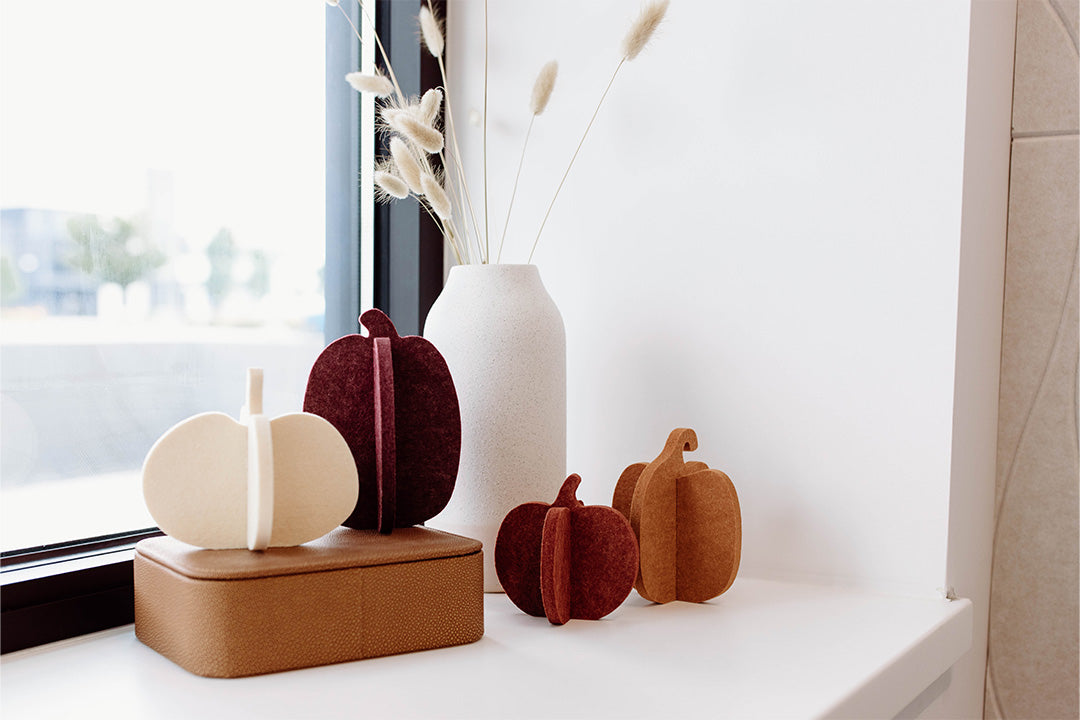Set of four felt pumpkins in different colors on a white background