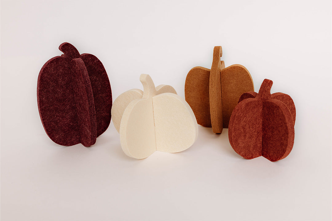 Set of four felt pumpkins in different colors on a white background