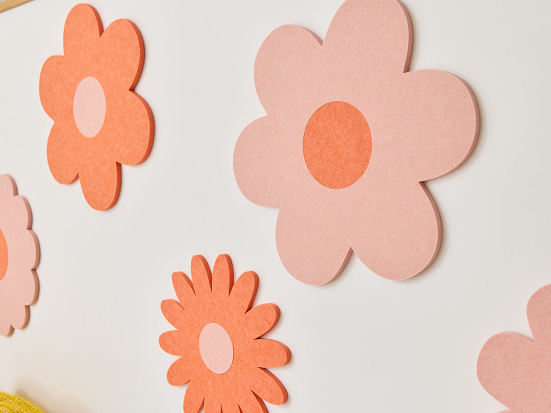 White sofa with colorful cushions and flower decals on a wall