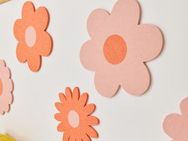 White sofa with colorful cushions and flower decals on a wall