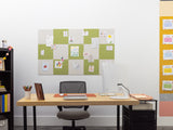 Home office with a desk, chair, and bulletin boards on the wall.