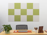 Checkered green and white wall panel above a desk with office supplies.