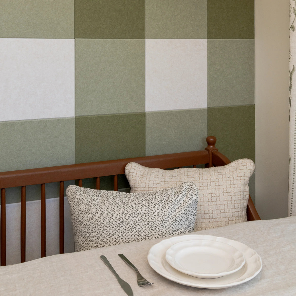Kitchen nook with a plate, two pillows, and a gingham accent wall