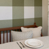 Kitchen nook with a plate, two pillows, and a gingham accent wall