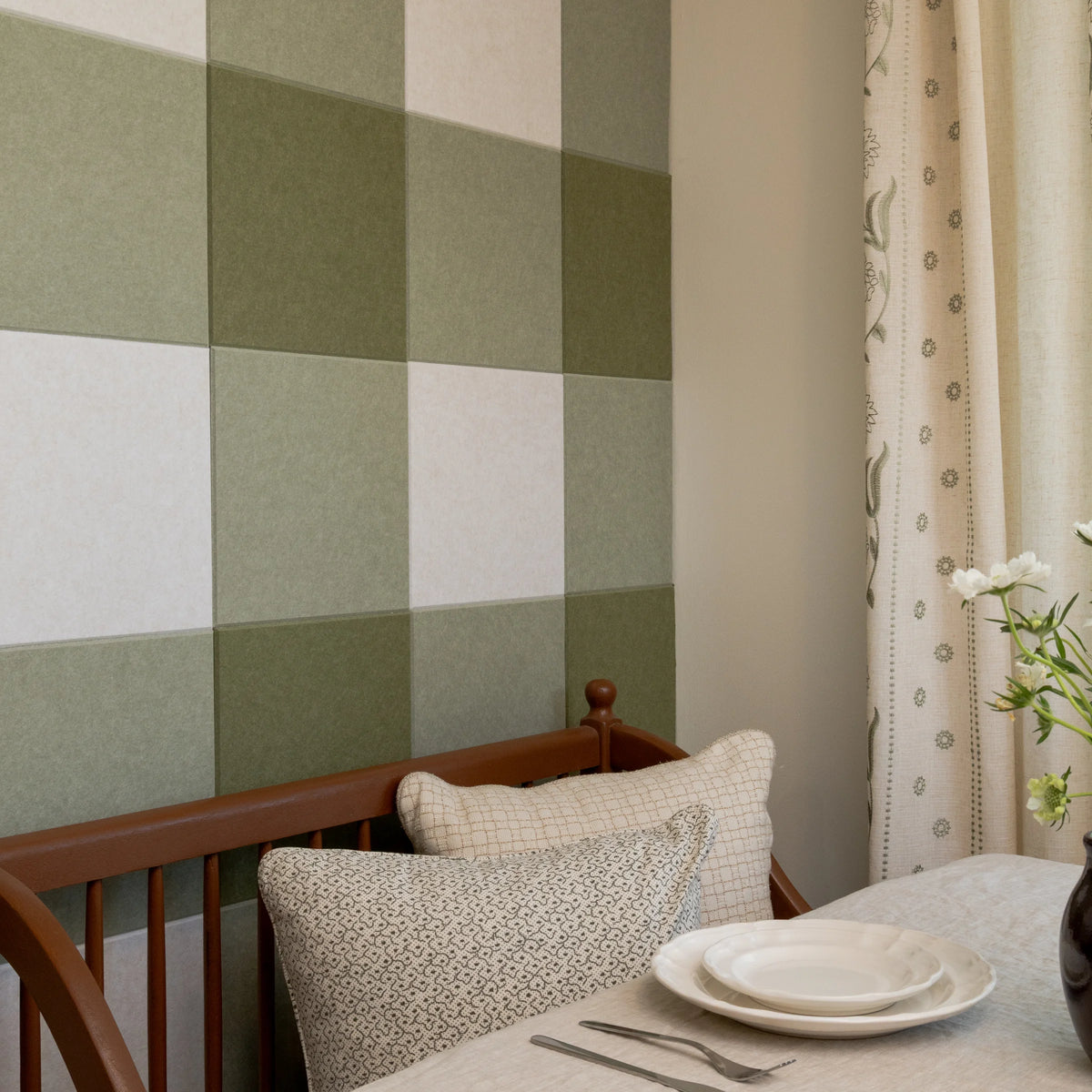 Close up shot of a kitchen nook with a gingham accent wall in multiple green colors.