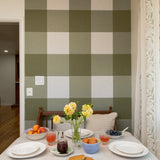 Gingham accent wall in a breakfast nook with places and fruit on the table.