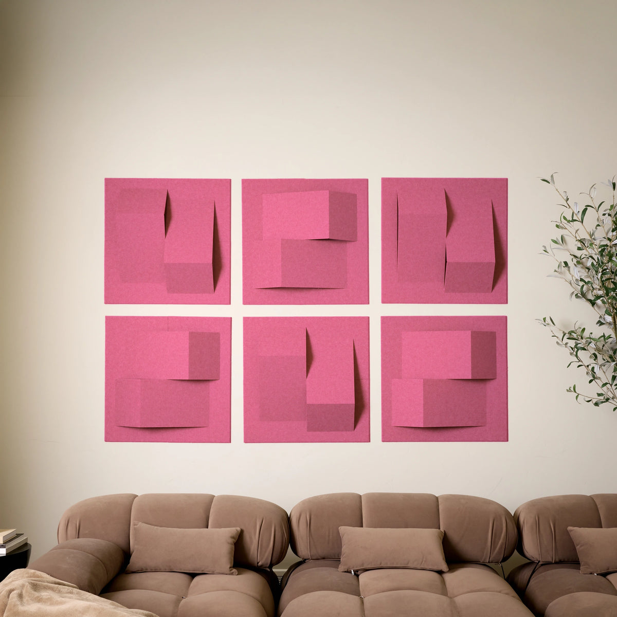 Hot pink felt tiles that have a 3D design to help with the acoustics of the room with a brown couch