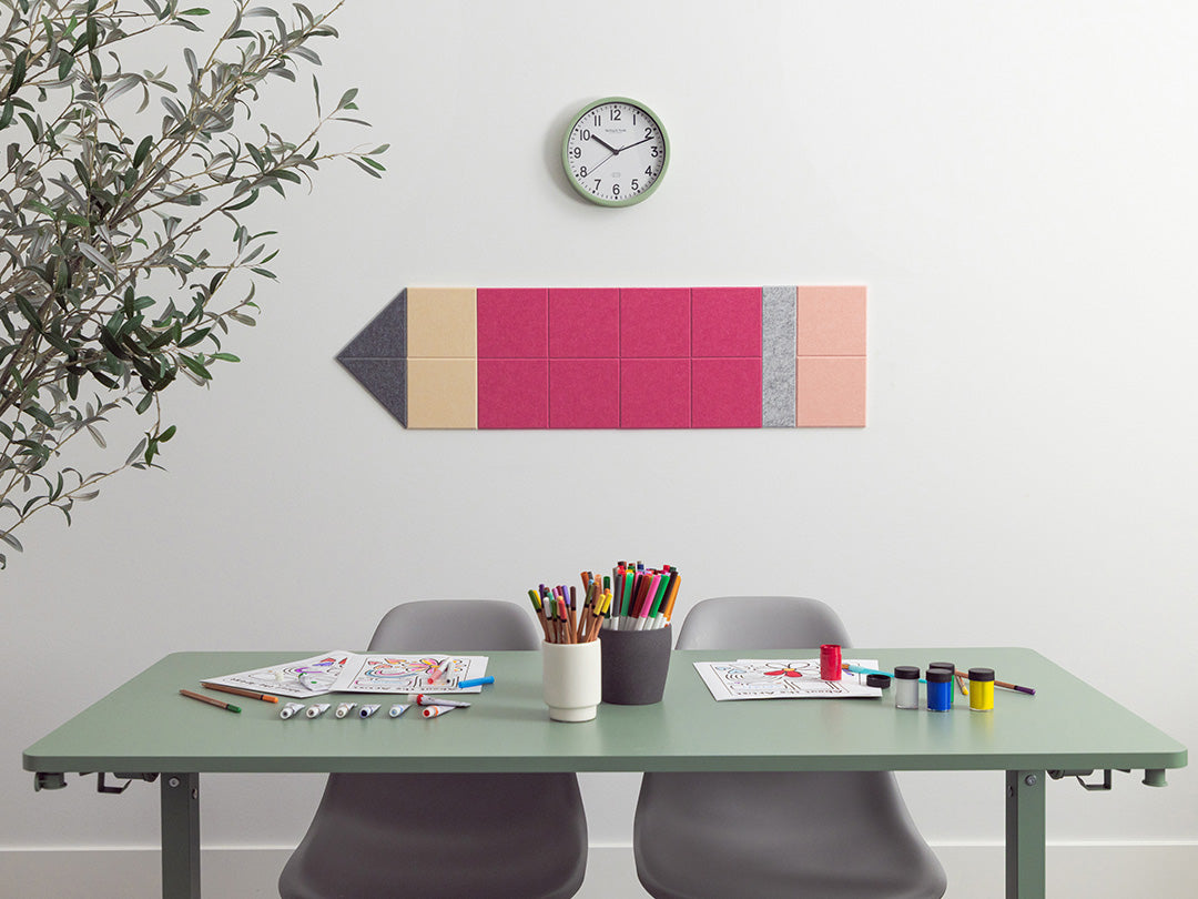 Color swatch wall art above a desk with stationery items