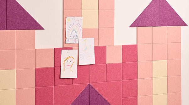 Colorful castle wall decal with kid's art pinned to it.