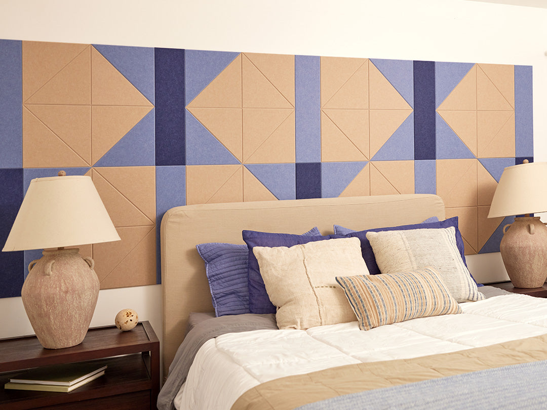 A Felt Right wall design in cream and blue behind a bed and two side tables and matching lamps