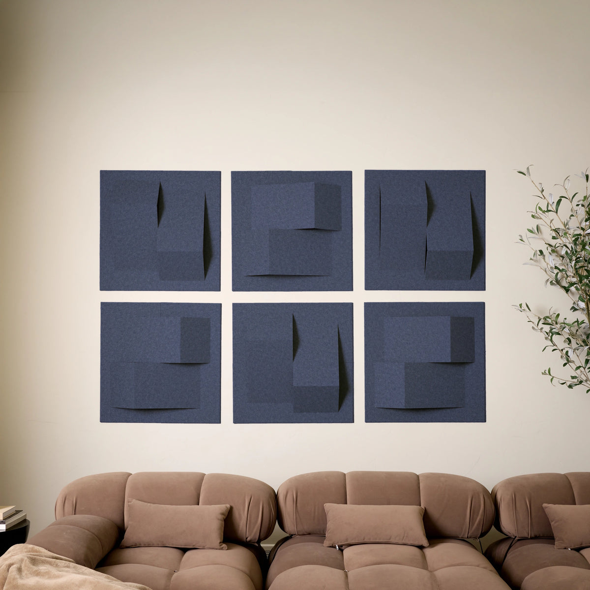 Dark blue acoustic felt tiles with peak designs on wall above the couch